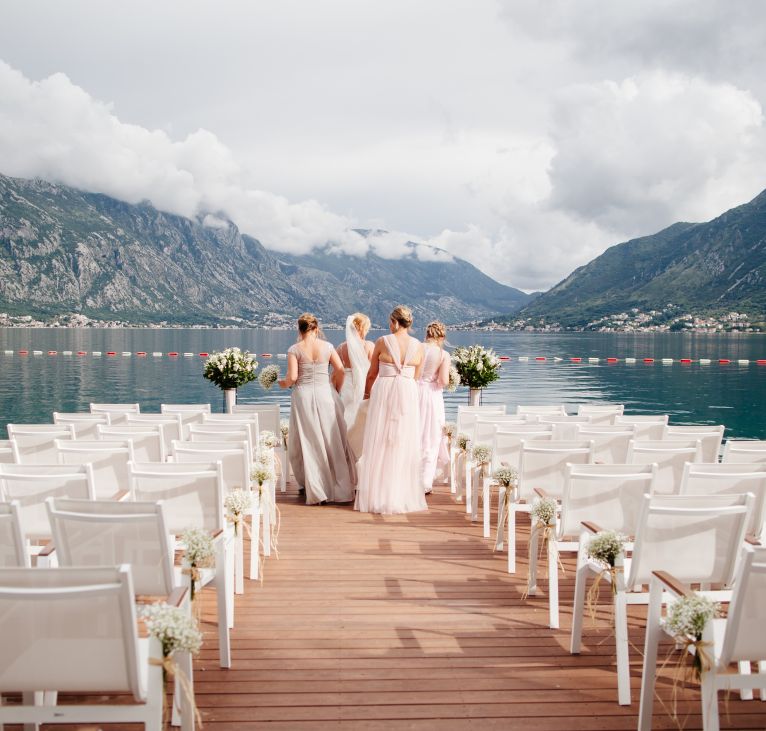 bride with bridesmaids at wedding in mountains. Wedding ceremony in picturesque location.